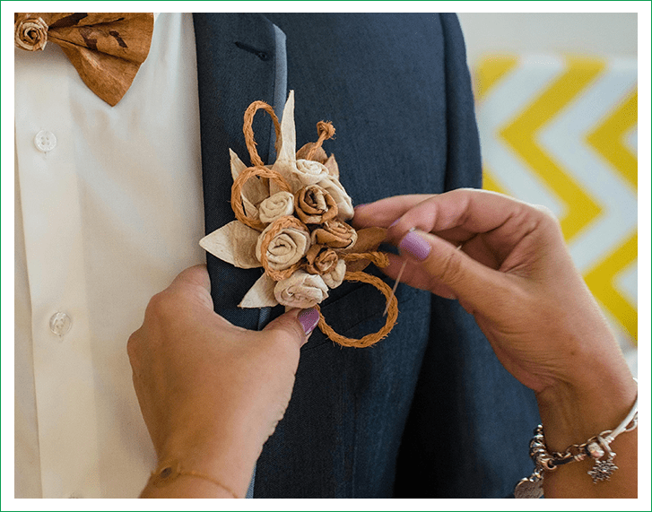 A person holding onto some flowers on their lapel
