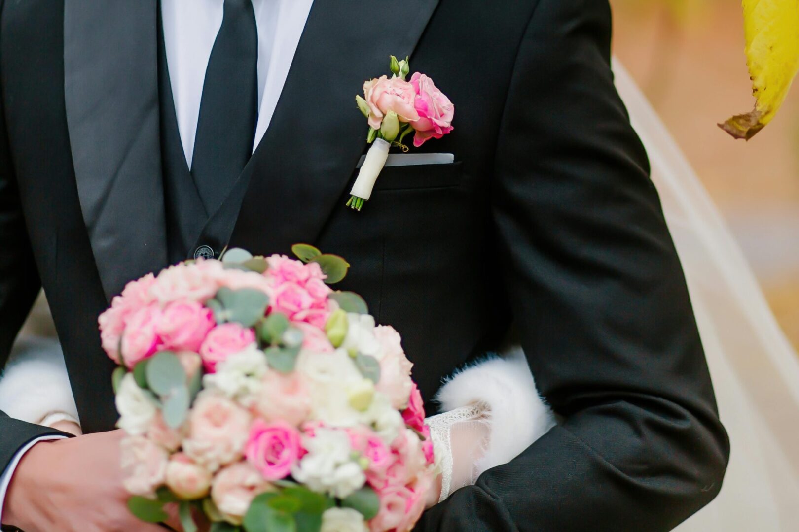 A man in suit and tie holding flowers.